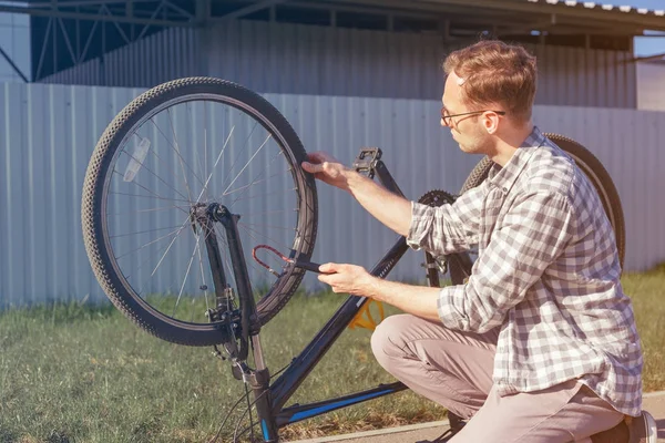 Man uses a bicycle pump. Cyclist repairs bike in trip.