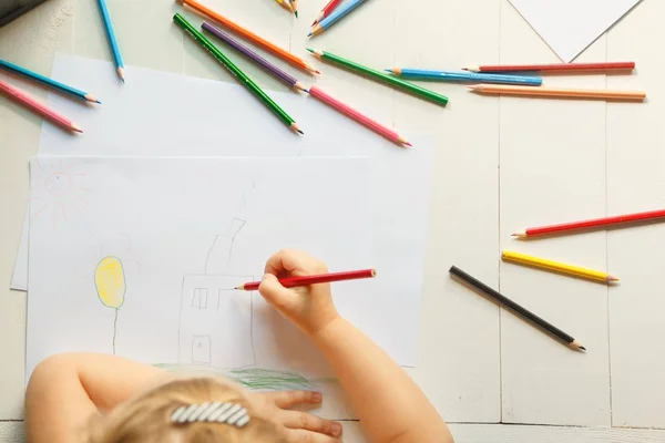 Το κορίτσι αντλεί το σπίτι της με χρωματιστά μολύβια. Το Top view — Φωτογραφία Αρχείου