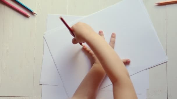 Una bambina delinea il contorno del palmo della mano su carta — Video Stock