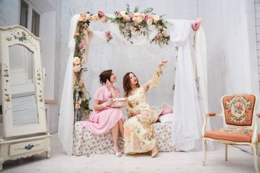 Mutlu kız gülümseme ve her diğer takı kendi yatak odasında oturuyor, göster