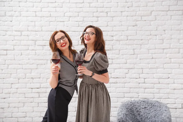 Duas meninas bonitas com copos de vinho na festa — Fotografia de Stock