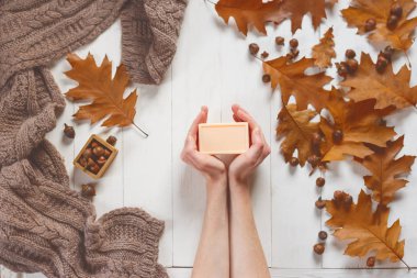 Yumuşak bir eşarp ve meşe yaprakları ile bir kompozisyon içinde erkek Katı sabun eller. Yukarıdan görüntüleyin. Güzellik ve bakım vücut ve el kavramı.
