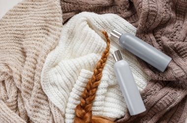 İki genç kadın yumuşak örme arka plan üzerinde yalan plastik şişe şampuan ve kırmızı tüyler ile boş