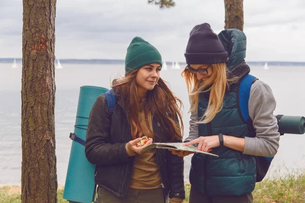 Deux femmes avec le regard à la mode recherche direction sur la carte de localisation tout en voyageant à la nature sauvage — Photo