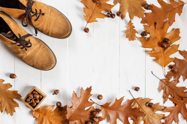 Sapatos de moda de gengibre de camurça com folhas de carvalho caídas amarelas no fundo de madeira branco. Vista superior com copyspace . — Fotografia de Stock