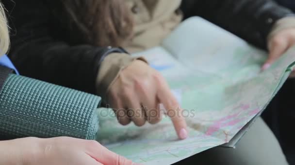 Close-up beeld van twee jonge toeristen vriendinnen op zoek naar richting op de kaart. Vrienden voor het verkennen van de wilde natuur — Stockvideo