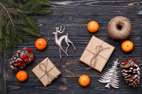 De giften van Kerstmis verpakt in kraftpapier op houten achtergrond. — Stockfoto