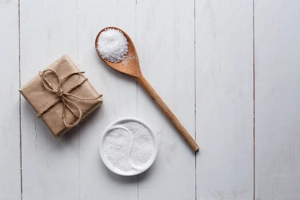 Healthy Sea Salt with giftbox on white wooden background. Flat lay. Copy space. — Stock Photo, Image