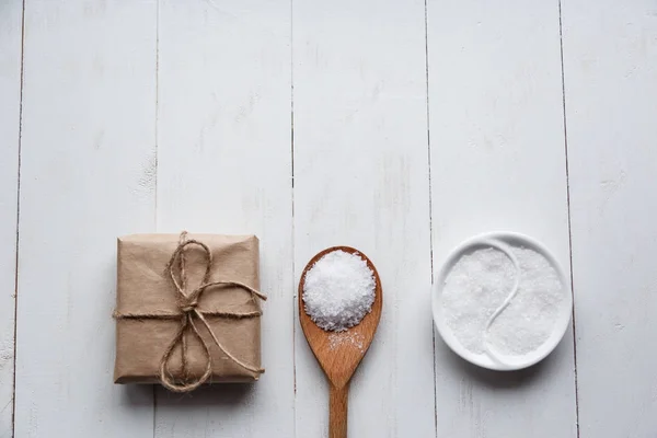 Healthy Sea Salt with giftbox on white wooden background. Flat lay. Copy space. — Stock Photo, Image