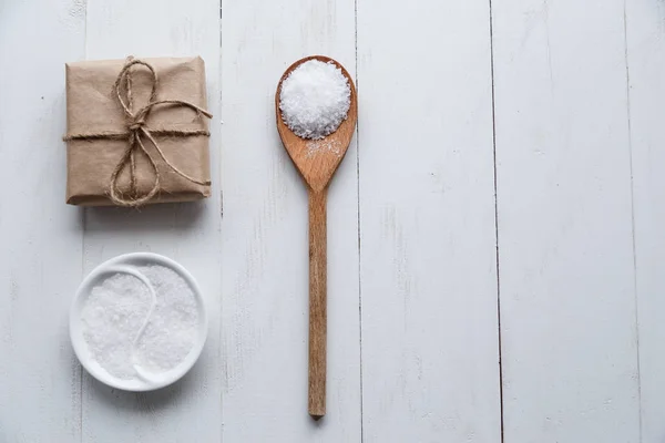 Healthy Sea Salt with giftbox on white wooden background. Flat lay. Copy space. — Stock Photo, Image