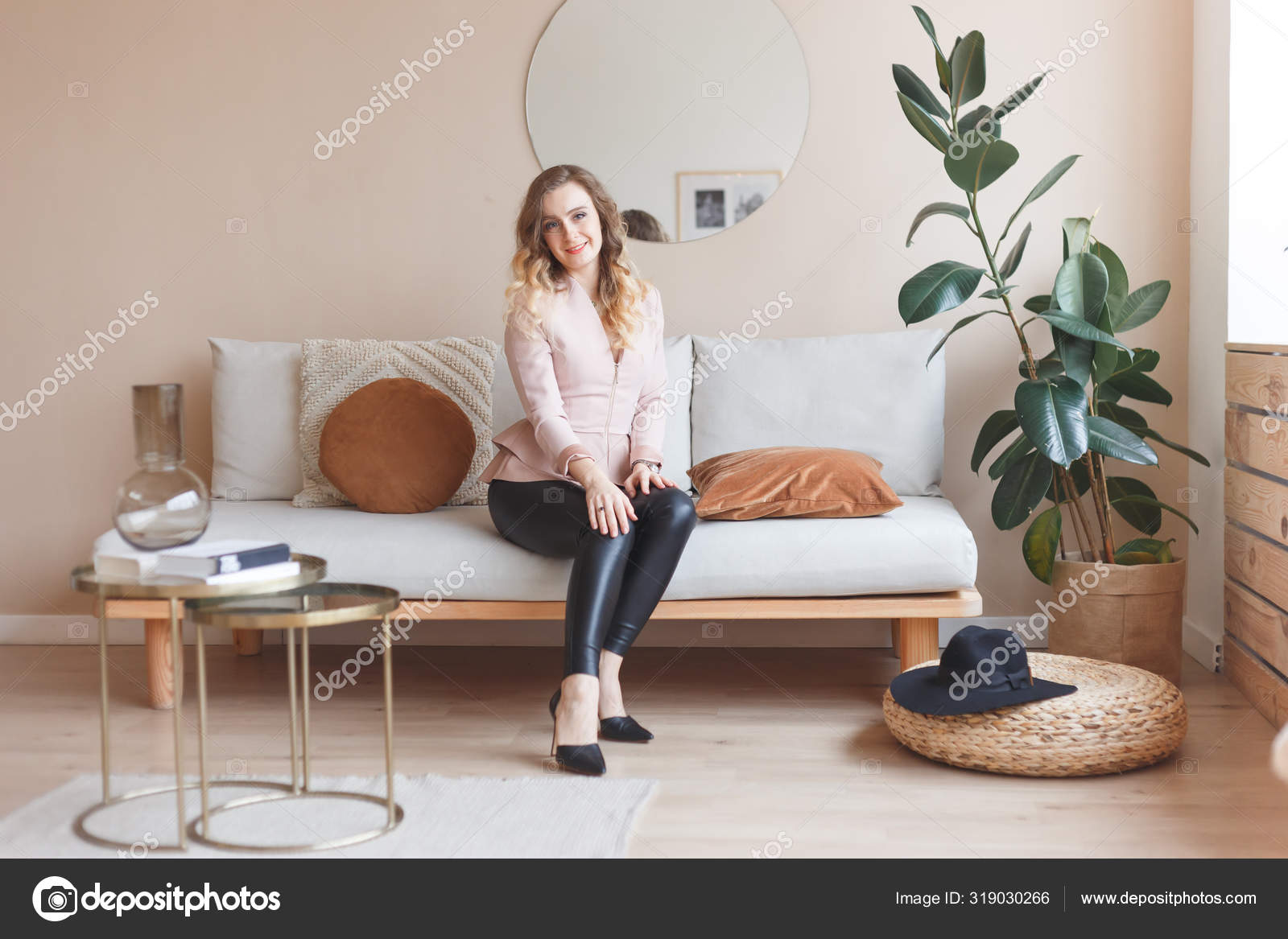 Girl in leather pants and high heels in room interior Stock Photo by