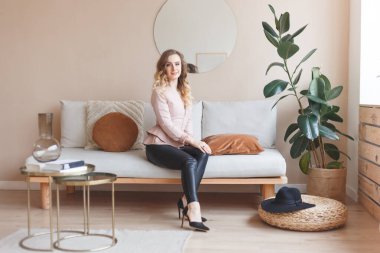 Deri pantolonlu ve topuklu ayakkabılı bir kız.