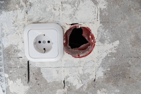 Electrical socket hole on concrete wall. Under construction electrical socket close up