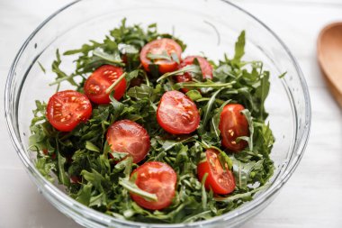 Roka salatası ve cam tabakta domates.