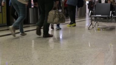 Sheremetyevo, Rusya - 08 Kasım 2019: Havaalanında bavul taşıyan insanlar, alçak çekim, kamera bacaklarını gösteriyor