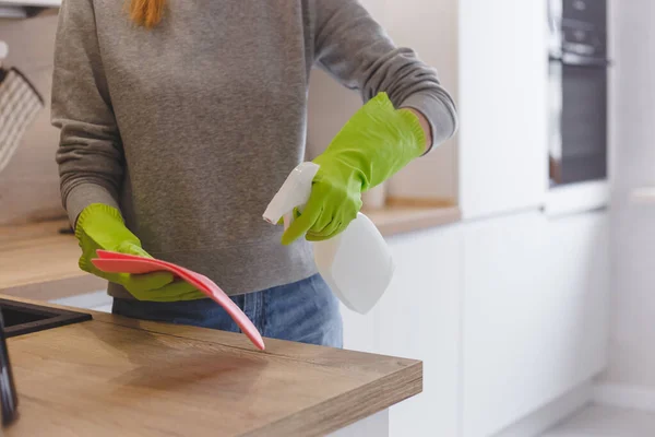 Närbild kvinna rengöring kök med rengöringsmedel spray och trasa. — Stockfoto