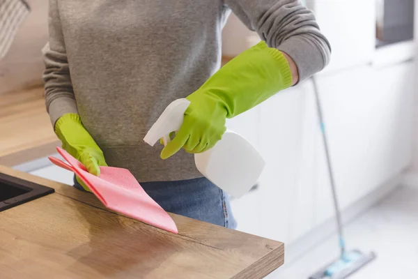 Közelkép nő takarítás konyha segítségével tisztító spray és ruha. — Stock Fotó