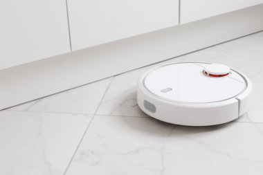 Robot süpürge odadaki fayansları süpürüyor.