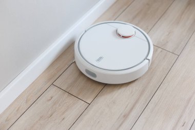Ev süpürgesi temizlik robotu odayı temizliyor.