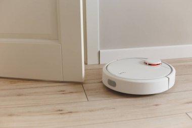 Ev süpürgesi temizleme robotu oturma odasının yakınında çalışıyor..