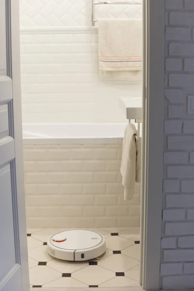 Белый робот пылесос в ванной комнате — стоковое фото