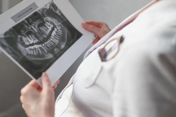Kobieta dentysty, patrząc na zdjęcie rentgenowskie. — Zdjęcie stockowe