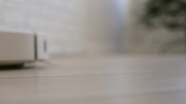Robot elektrikli süpürge soldan sağa hareket eder. Düşük açı, yakın görüntü