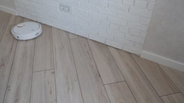 Robot elektrikli süpürge zemini süpürür, duvar boyunca hareket eder ve geri döner.