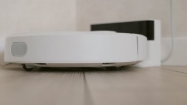 Robot elektrik süpürgesi şarj aletinden başlar ve uzaklaşır.