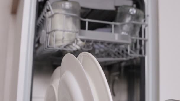 Nő tesz fehér piszkos tányér mosogatógép kosár és közelről kéz