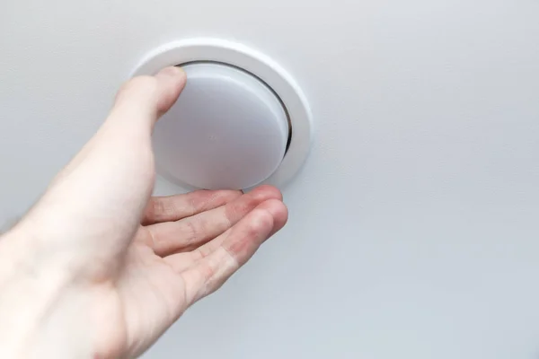 Mão detém uma lâmpada LED baixo consumo de energia, a substituição de lâmpadas no teto . — Fotografia de Stock