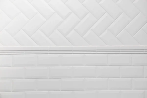 Стена ванной комнаты выложена плиткой в скандинавском стиле с белой затиркой. Подключение двух различных макетов плитки herringbone и кирпичной стены — стоковое фото