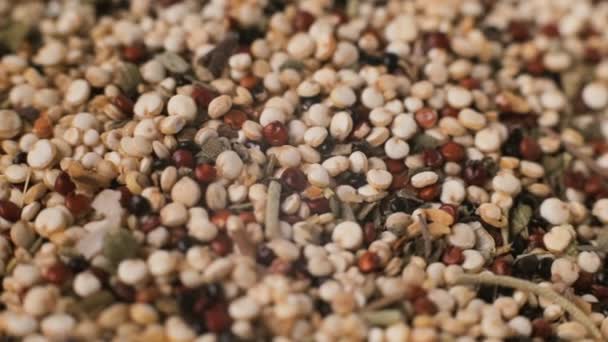 Mixed uncooked quinoa vegetarian crop with spices is rotating macro background — Stock Video