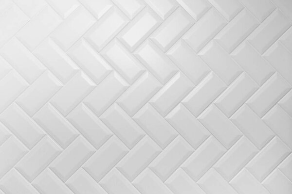 Срезанная белая матовая керамическая плитка рисунок herringbone на стене
.