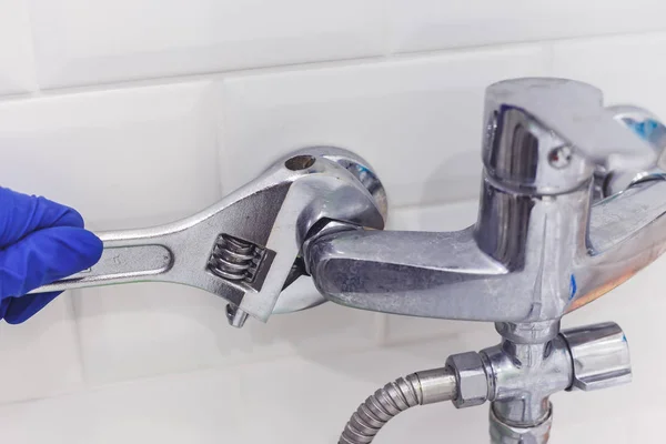 Fontanero utiliza llave de tubo para grifo mezclador de ducha de servicio —  Fotos de Stock