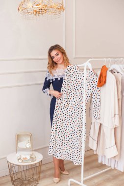 Özel bir galeride, elbise içinde benekli elbise seçen genç bir kadın.