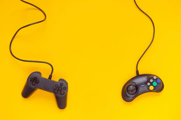 Dois gamepads com fio ou controladores de vídeo game em fundo amarelo. Vista superior, flat lay. Indústria de jogos, consola — Fotografia de Stock