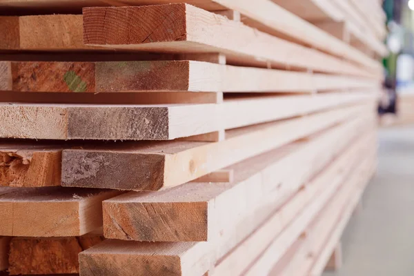 Αποθήκη ή εργοστάσιο για πριόνισμα σανίδων σε εσωτερικό πριονιστήριο. Ξυλεία στοίβα από ξύλινα άσφαιρα υλικά κατασκευής. Βιομηχανία καταγραφής. — Φωτογραφία Αρχείου
