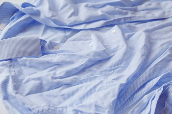 Blauw katoen gerimpeld en gerimpeld shirt op wit. Gewassen overhemd na droger — Stockfoto
