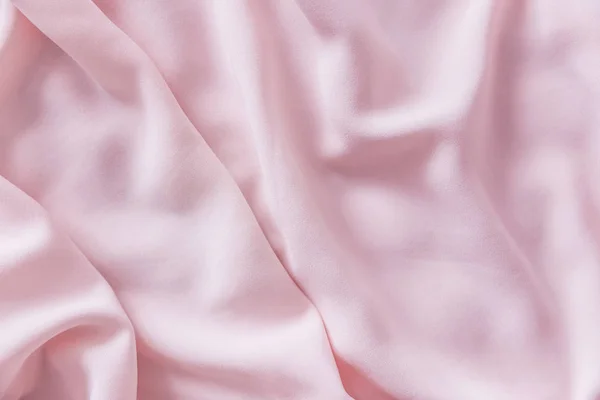 Pink wrinkled silk fabric. The pink fabric is laid out waves. Pink fabric background or texture. — Stock Photo, Image