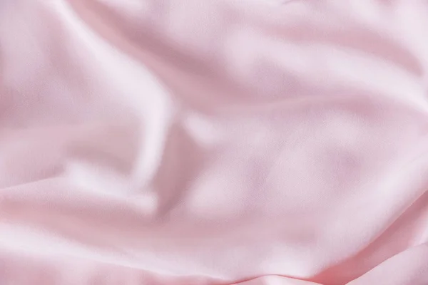 Розовая морщинистая шелковая ткань. Розовая ткань проложена волнами. Розовый фон или текстура ткани . — стоковое фото
