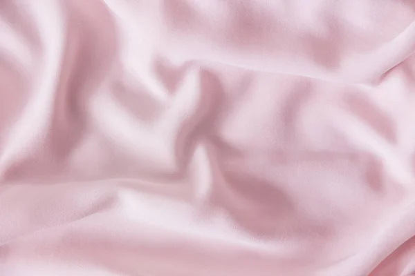 Pink wrinkled silk fabric. The pink fabric is laid out waves. Pink fabric background or texture. — Stock Photo, Image