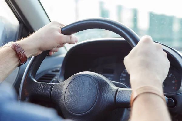 Manos de un hombre en el volante de un primer plano del coche — Foto de Stock