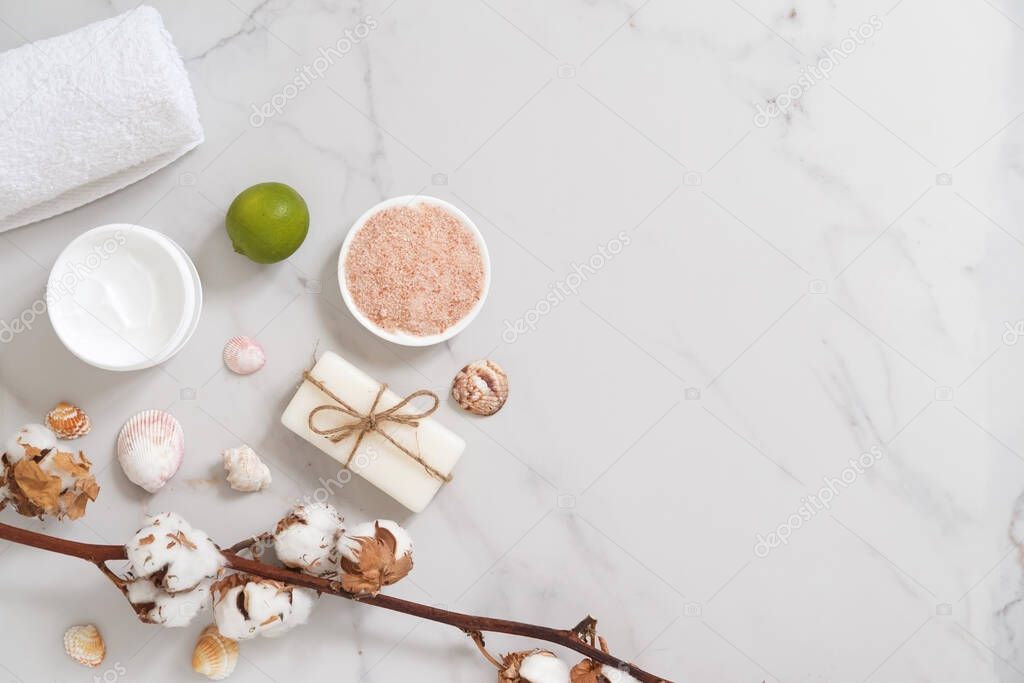 Spa cosmetics set on white marble background from above. Beauty blogger concept. Copy space
