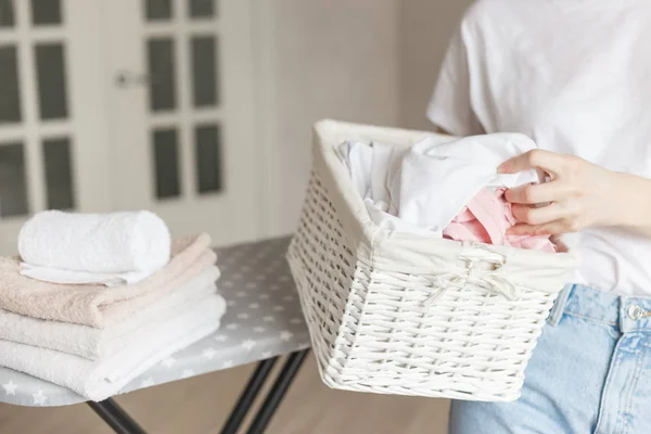 Cesta rústica de mimbre con ropa lavada en mano de mujer lista para planchar — Foto de Stock