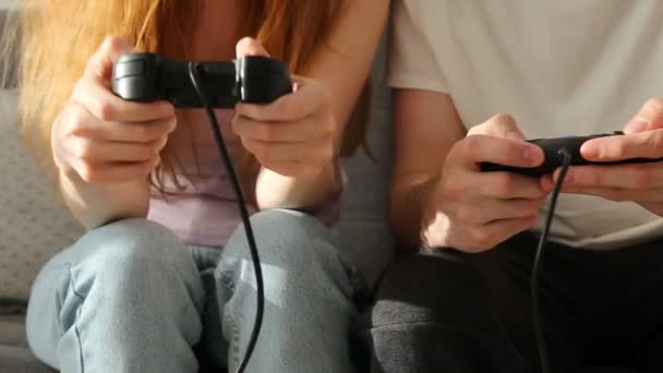 Giovane coppia, una ragazza e un ragazzo stanno giocando la console. La ragazza è felice di vincere. — Video Stock