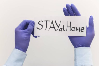 Elinde kağıt olan bir doktor evde kalıp Coronavirus veya Covid-19 salgınından korur. Beyaz üzerine üst görünüm