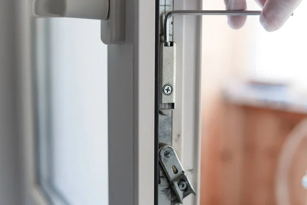 Рука Man робить налаштування обладнання дверного механізму uPVC за допомогою алюмінієвого ключа . — стокове фото