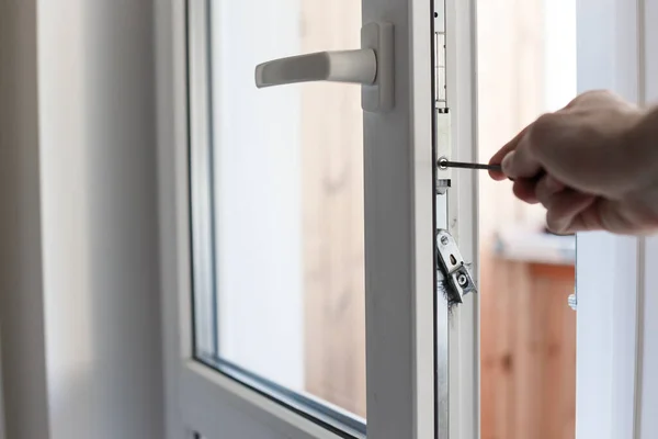 Рука Манса использует отвертку для настройки механики дверей . — стоковое фото