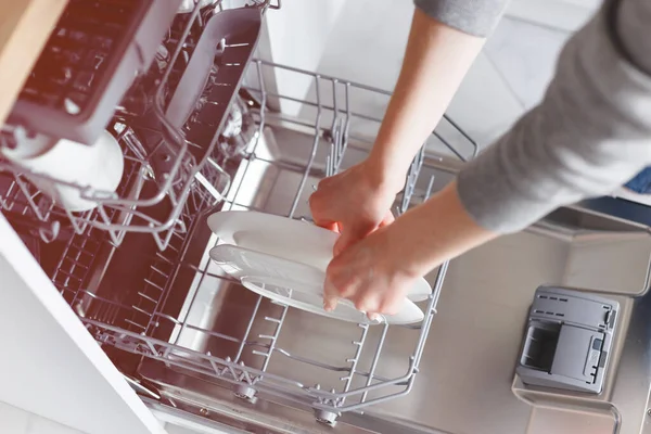 Close-up of female hands putting dishes to the dishwasher. — Stock Photo, Image